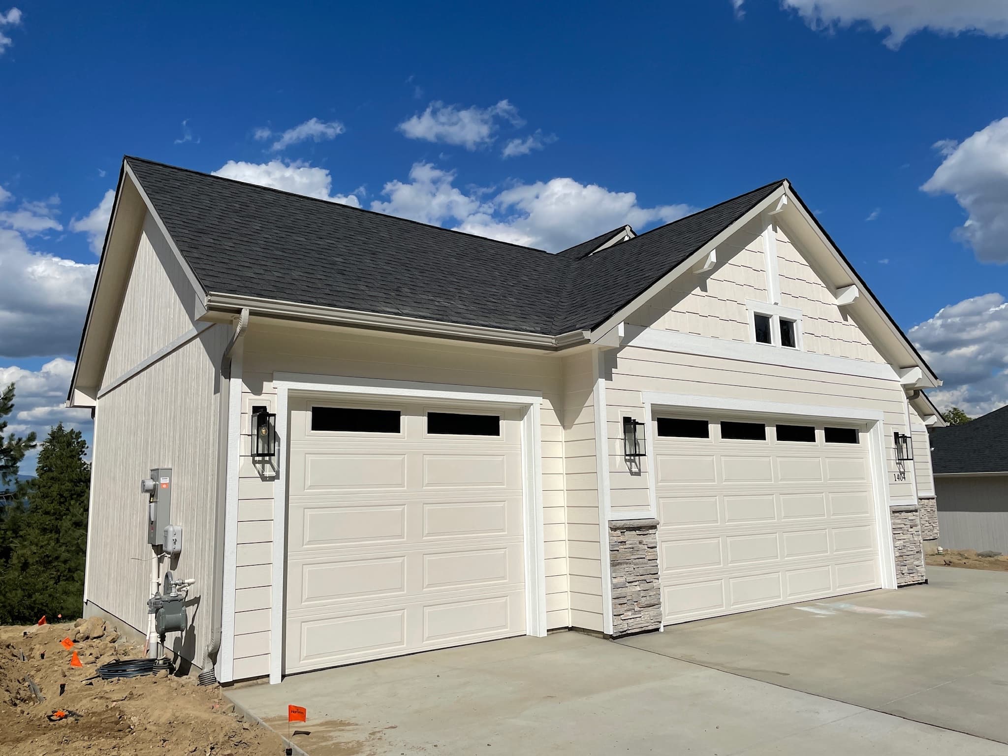 White Spokane, WA garage siding after exterior repaint with clean stone accents
