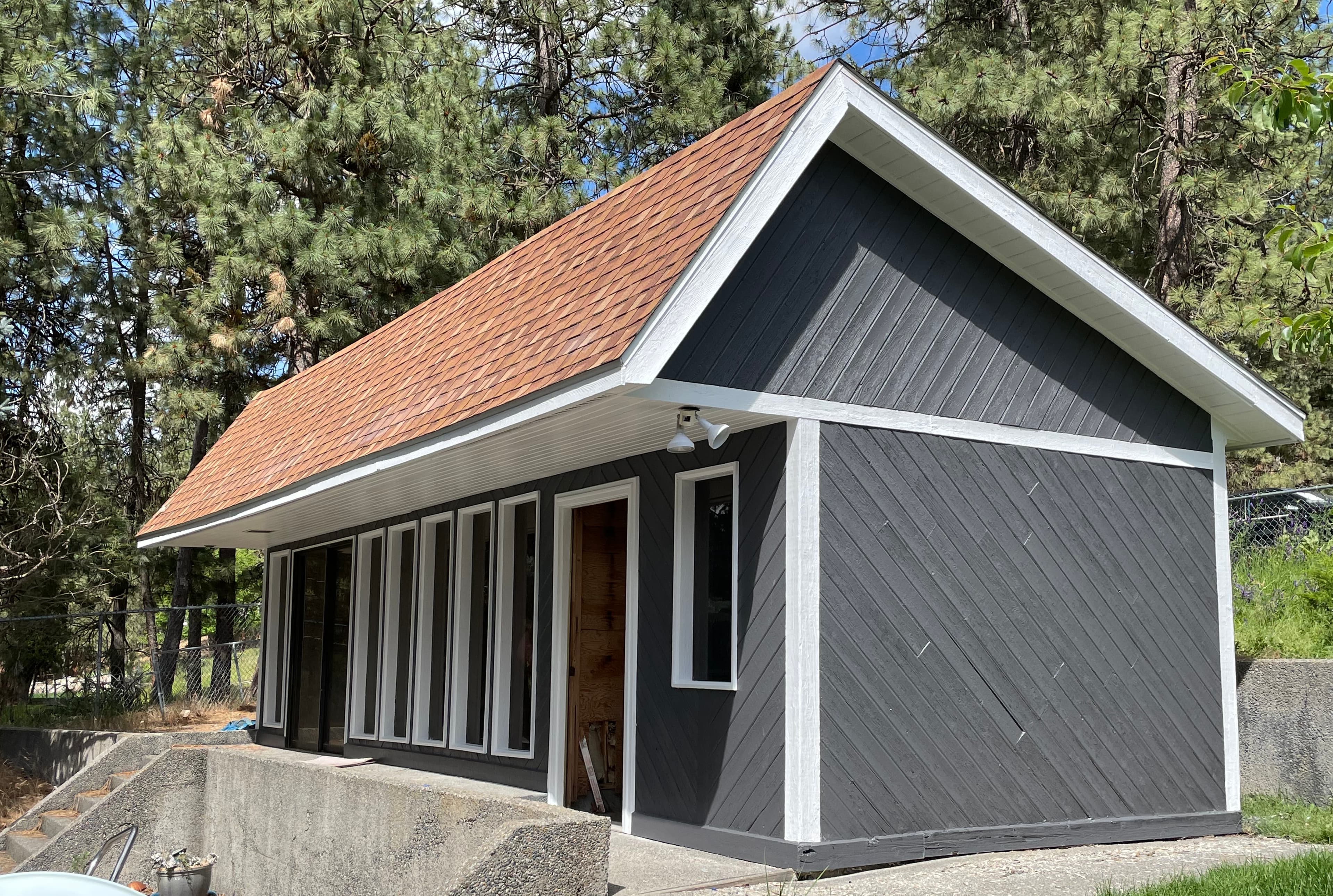 Gray vertical siding exterior repaint on a Spokane, WA wooded outbuilding