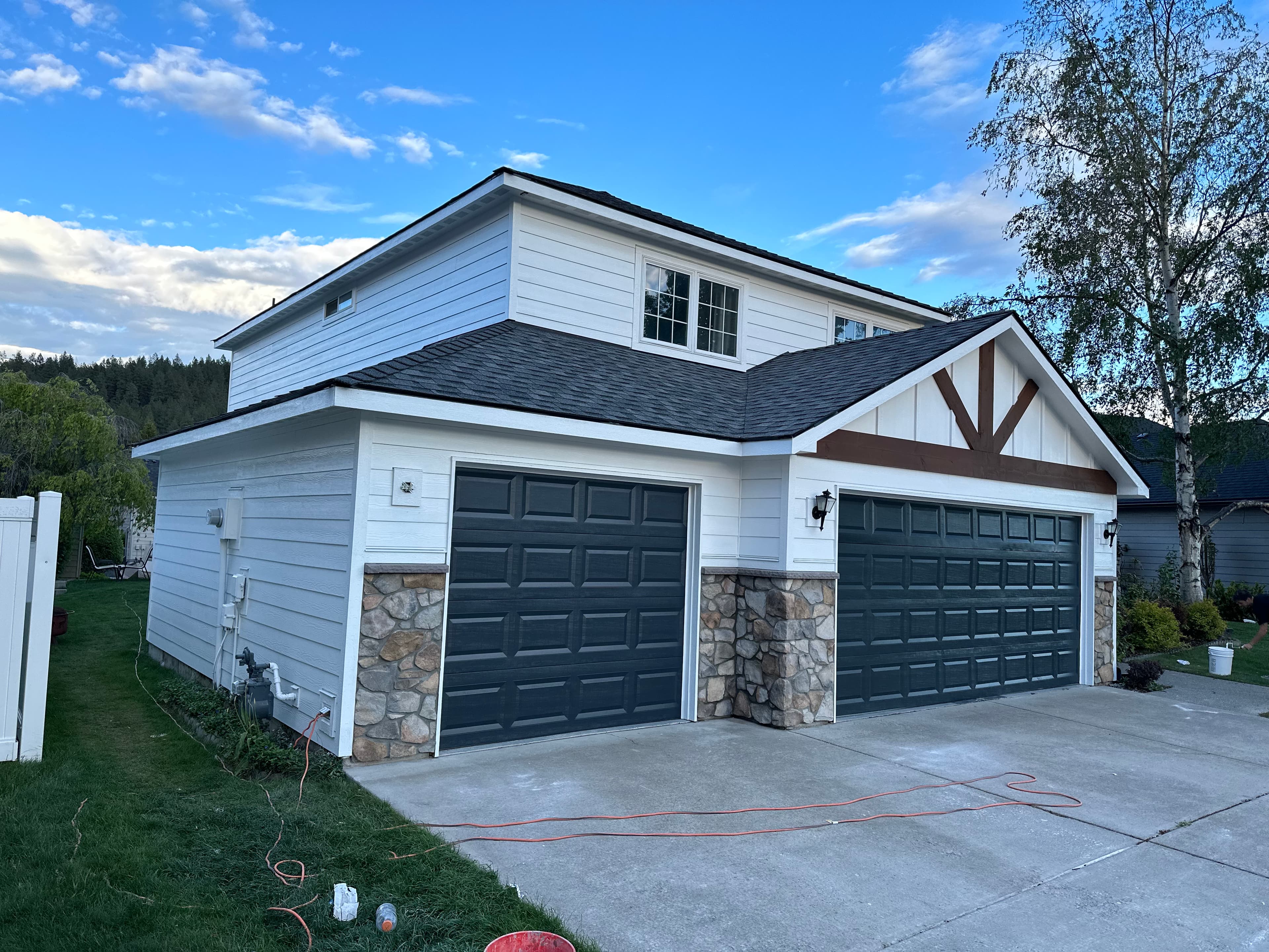 White Spokane, WA garage siding exterior repaint with dark doors and timber accent