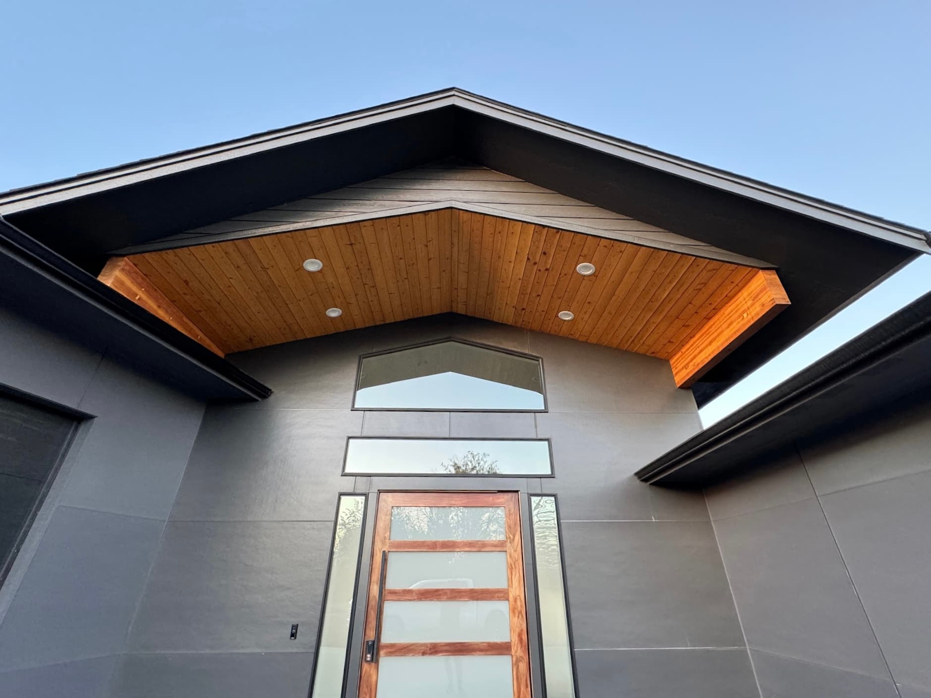 Modern Spokane, WA entry soffit finishing above a gray facade and taped front door