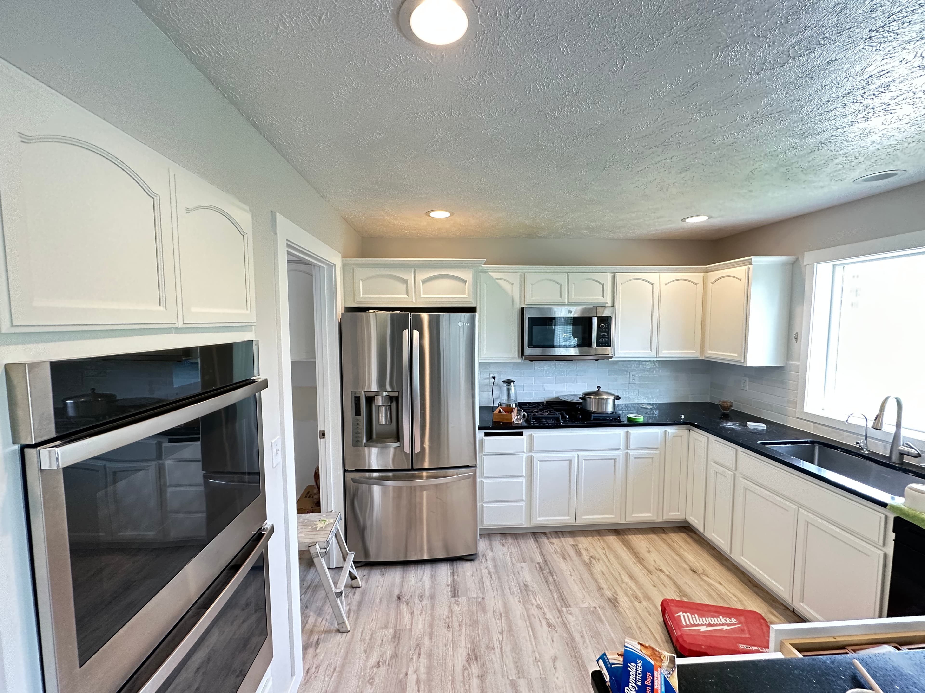 White Spokane, WA kitchen cabinet refinishing with dark counters